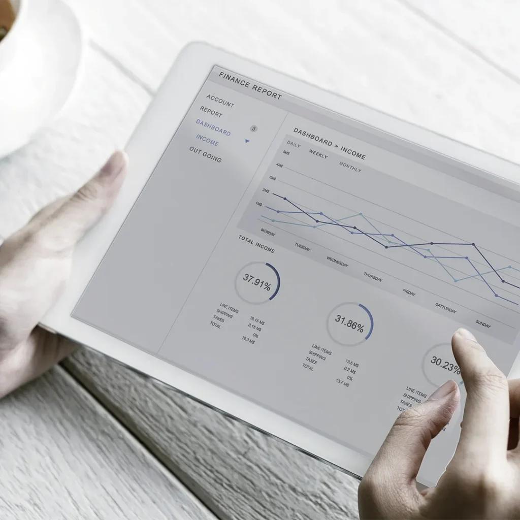 Top down view of a person using a tablet with charts and graphs displaying on screen